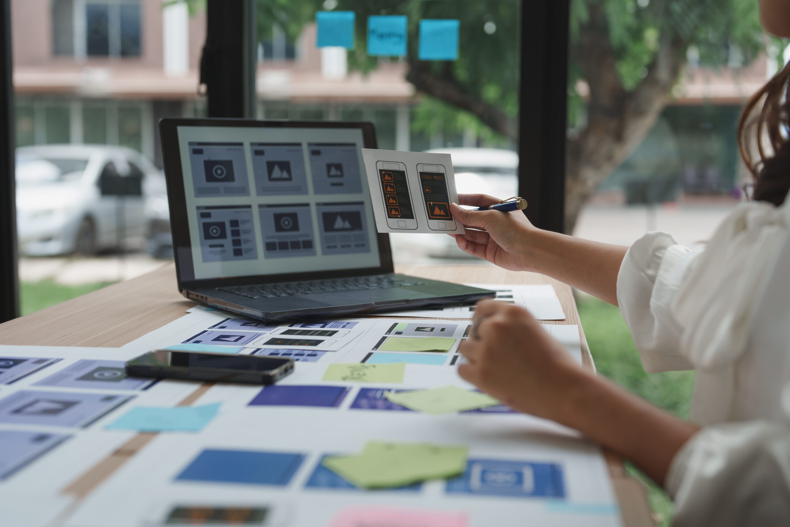 Web designer working on user interface and user experience, comparing mobile and desktop website layouts